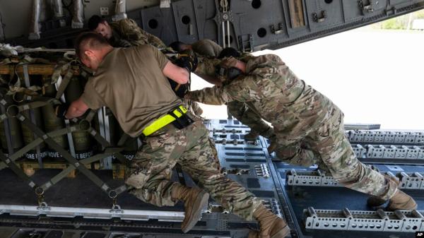 USAF airmen push over 8,000 pounds of 155 mm shells on to a C-17 cargo aircraft bound for Ukraine, April 29, 2022.