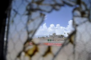 ARCHIVO - En esta imagen del 23 de agosto de 2013 revisada por el Departamento de Defensa de Estados Unidos se observa uno de los dos edificios de tribunales en la Base Aeronaval de Guantánamo a través de una ventana rota en el Campamento Justicia, en la base de Guantánamo, Cuba.