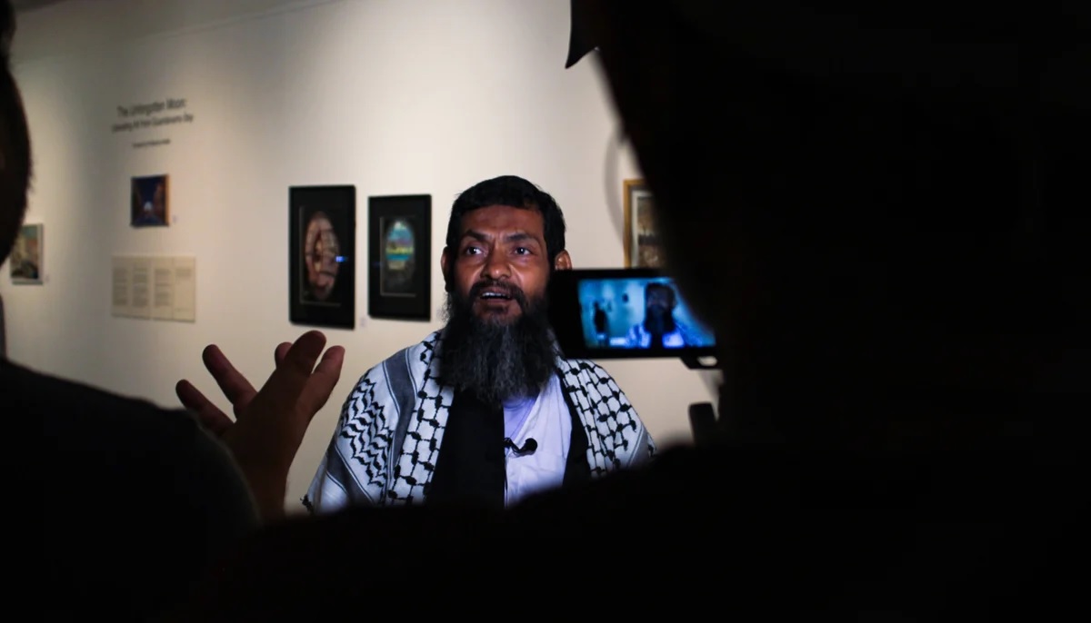 Ahmed talks to the media during his exhibition at the IVS gallery.  Photo by Hassaan Ahmed