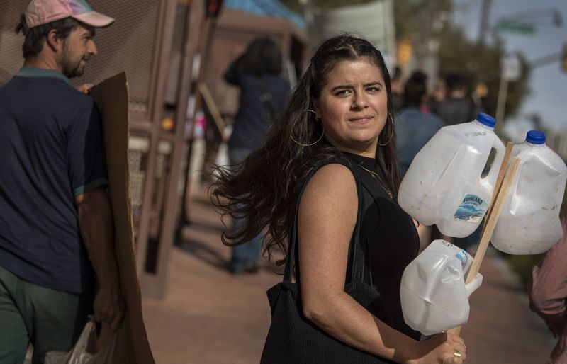 Zaachila Orozco-McCormick, voluntaria de No More Deaths, marcha con jarras de agua vacas despus de su sentencia por delitos menores que involucran dejar la ayuda en un rea restringida del Refugio Nacional de Vida Silvestre Cabeza Prieta. (Brian van der Brug / Los Angeles Times)