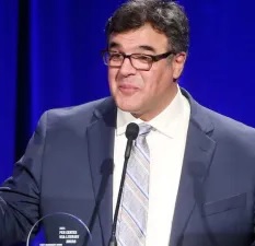 Una persona con traje y corbata de pie en un podio Descripcin generada automticamente con confianza baja