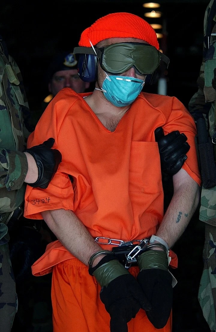 David Hicks, un australiano que fue capturado luchando pata los talibanes, es conducido desde un avión de carga el primer día de operaciones de la prisión en la Bahía de Guantánamo. Foto Sargento de Estado Mayor Jeremy T. Lock vía The New York Times.