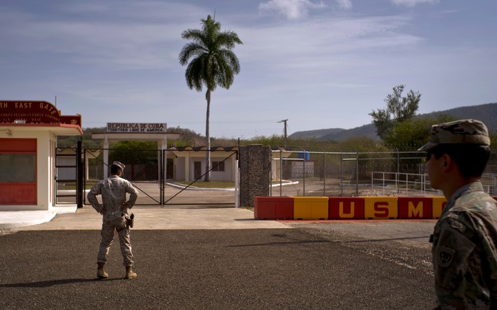 Un soldado del Ejrcito, a la derecha, y un marine posan frente a las puertas que separan el lado cubano de la base naval estadounidense de la Baha de Guantnamo, el 6 de junio de 2018. (Foto AP/Ramn Espinosa, archivo)