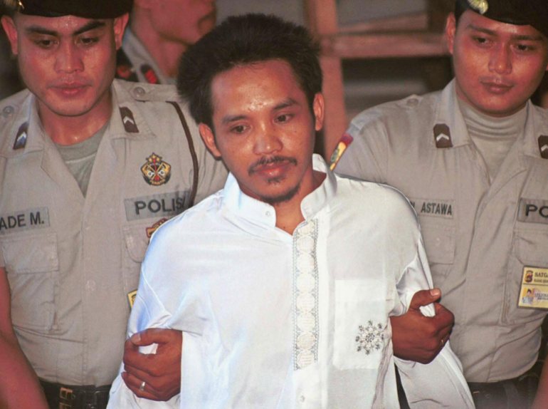 Ali Imronm, vestido con un pantalón corto blanco y escoltado por dos policías, fue declarado culpable de los atentados de Bali en un tribunal de Indonesia.