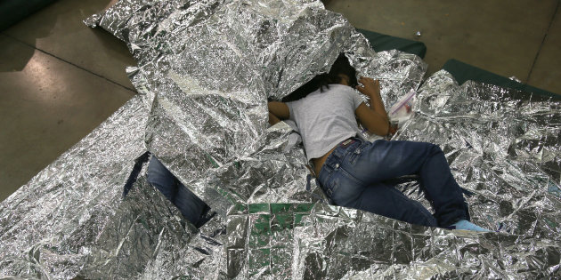 Una nia centroamericana descansa sobre mantas trmicas en un centro de detencin dirigido por la Patrulla Fronteriza de los Estados Unidos.