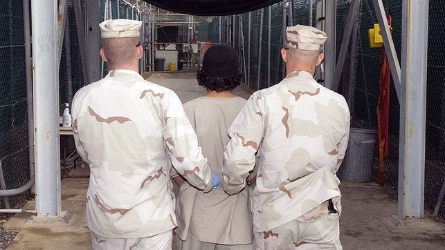 Dos soldados trasladan a un detenido en un campo de prisioneros de Guantnamo. Foto: Wikimedia