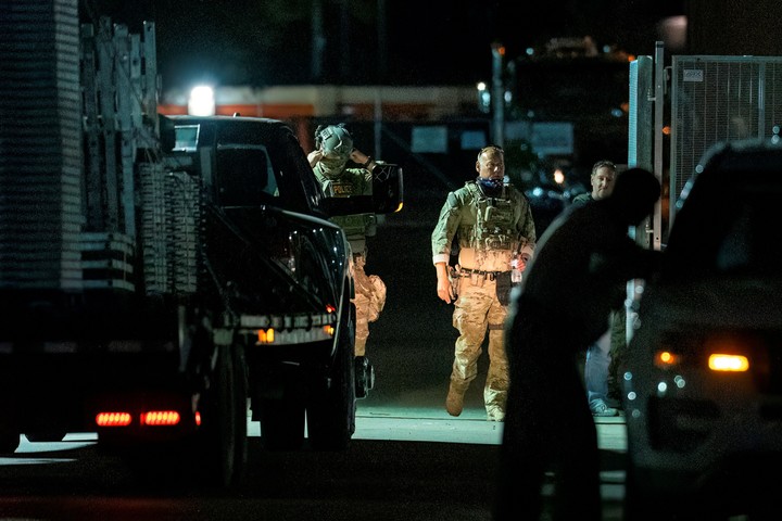 Agentes federales abren la puerta de una valla construida en Beach Street para dejar entrar un camin fuera de las instalaciones de procesamiento de ICE en Broadview, en las afueras de Broadview, el martes 14 de octubre de 2025. (Tyler Pasciak LaRiviere/Chicago Sun-Times va AP)